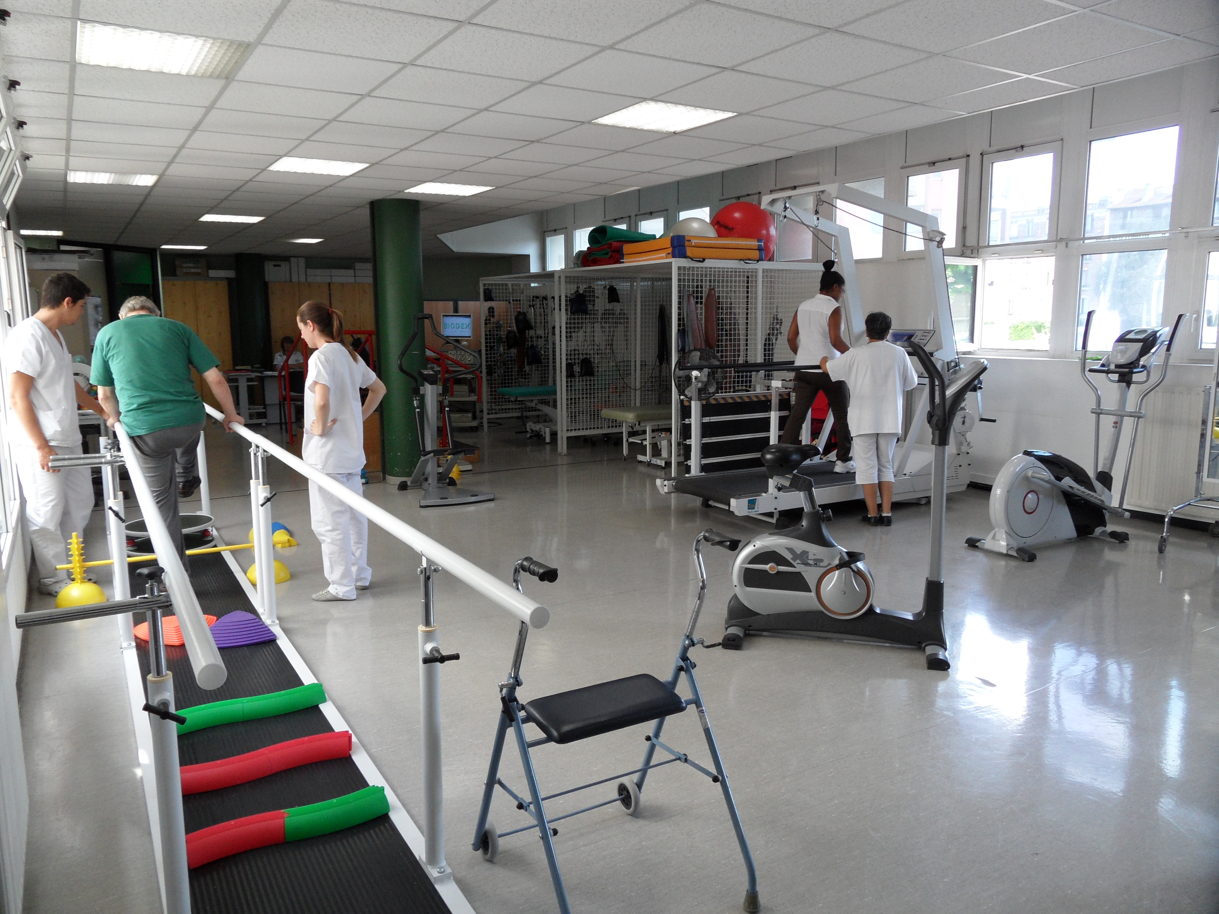 Salle de rééducation avec du personnels soignants et des patients 