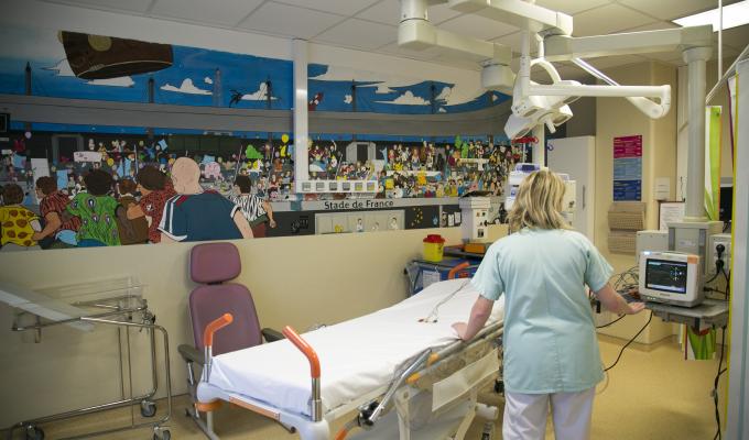 Une infirmière avec un lit dans le bloc opératoire 