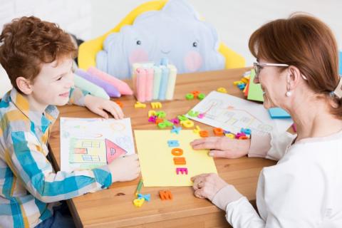 Une orthophonistes et un enfant dans une salle 