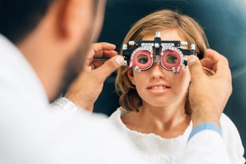 Un orthoptiste qui utilise un appareil pour les yeux sur une patiente 