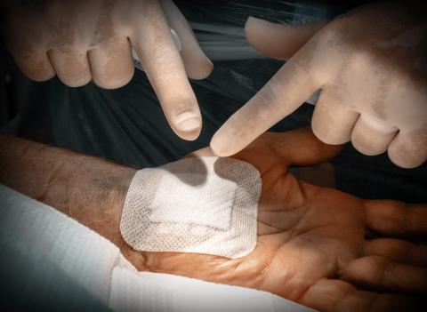 deux mains qui ajuste un pansement sur le poignet d'une personne 