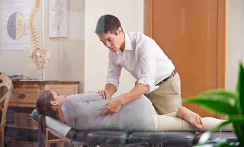 un médecin qui ausculte une patiente qui est allongée