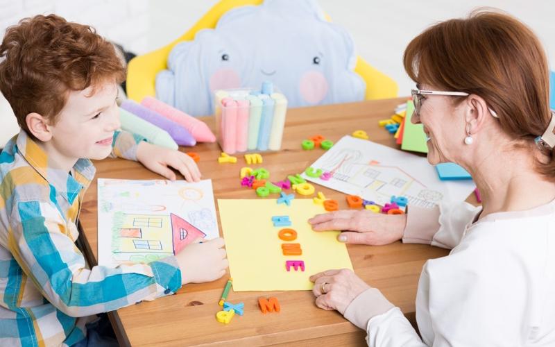 Une orthophonistes et un enfant dans une salle 