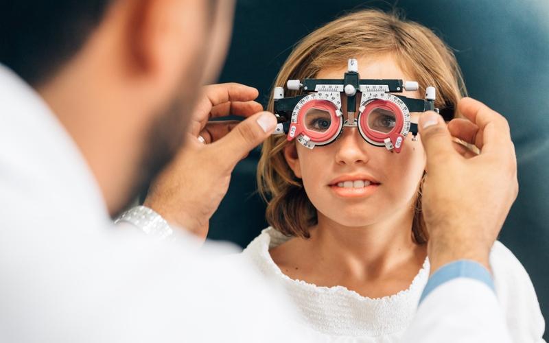 Un orthoptiste qui utilise un appareil pour les yeux sur une patiente 